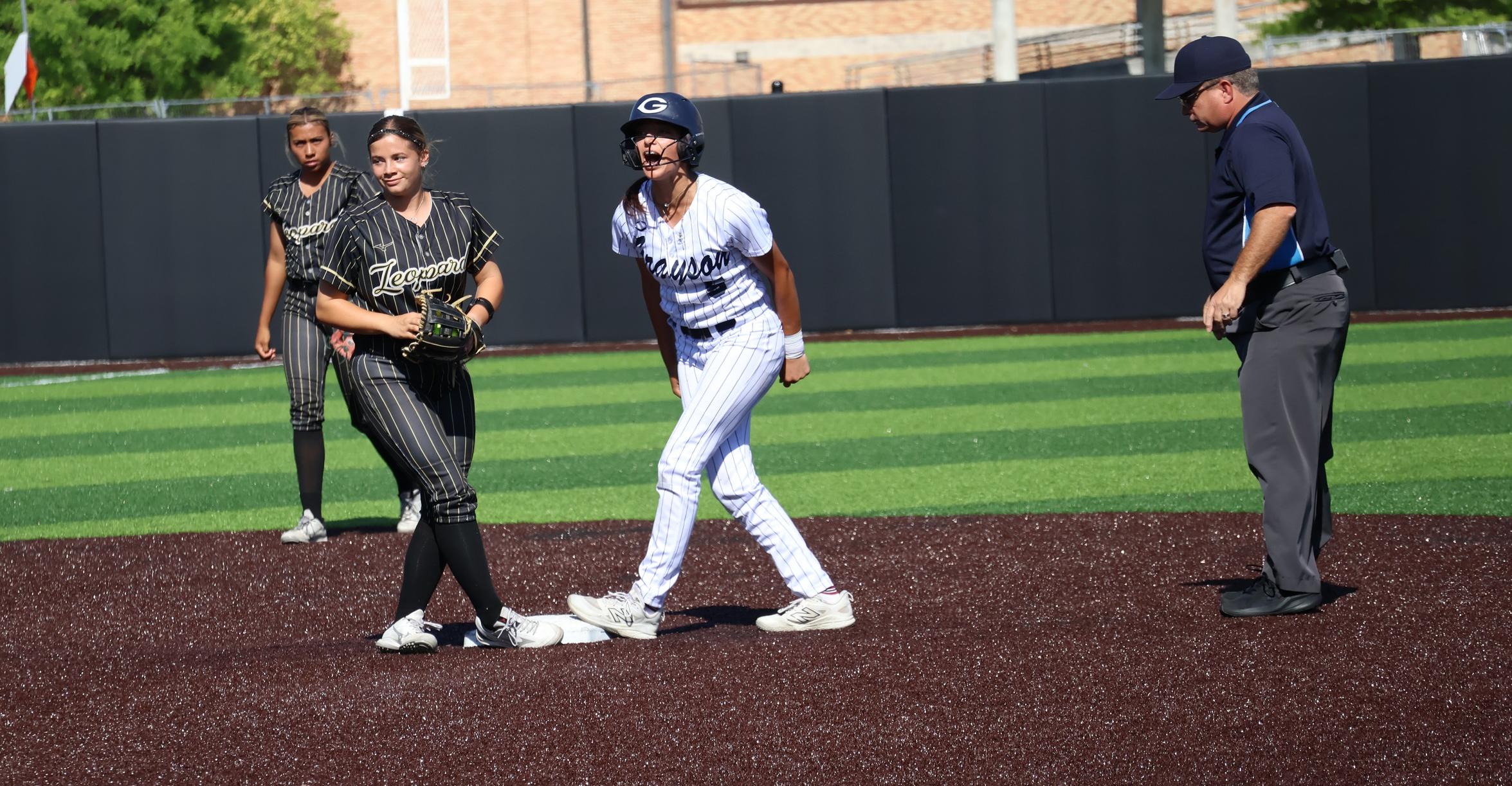 The player in the white jersey celebrates after hitting a double and reaching second base in the softball game on Thursday, May 14. 
