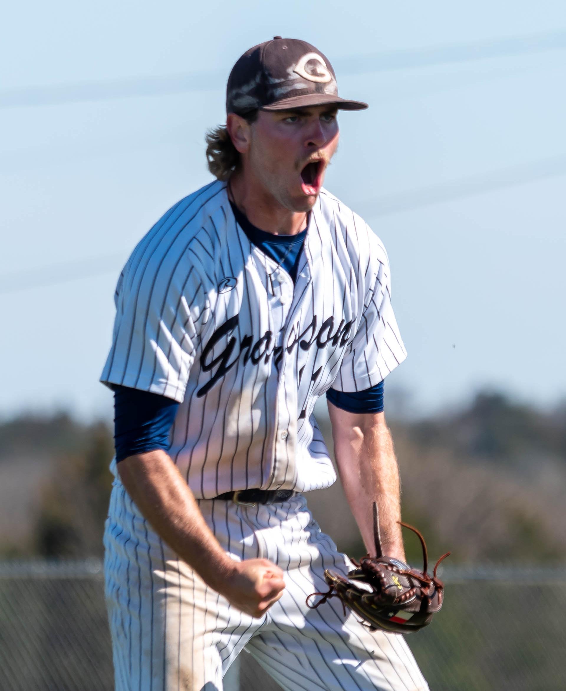 The baseball player celebrates a big play in the game. 